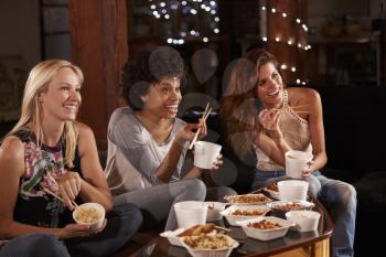 Three female friends eating a Chinese take-away watching TV