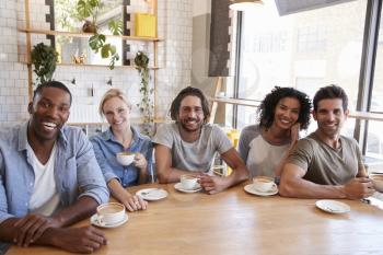 Portrait Of Friends Meeting Around Table In Coffee Shop
