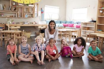 Portrait Of Teacher With Pupils In Montessori School Classroom