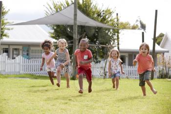 Children At Montessori School Having Fun Outdoors During Break