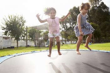 Children At Montessori School Having Fun On Outdoor Trampoline