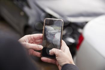 Woman Taking Photo Of Car Accident On Mobile Phone