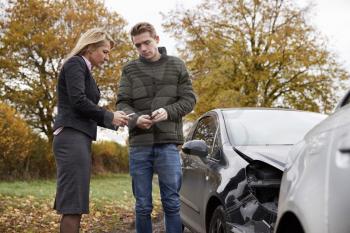 Two Drivers Exchanging Insurance Details After Car Accident