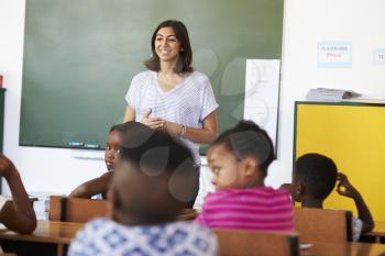 Female volunteer teacher in front of class at an elementary school