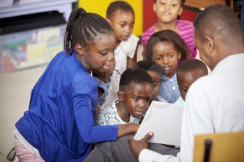 Teacher showing kids a book during elementary school lesson