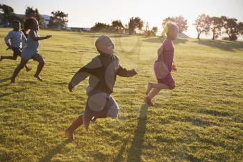 Elementary school boys and girls running in an open field