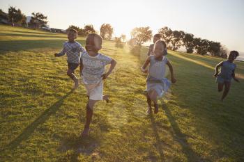 Elementary school kids running to camera in an open field