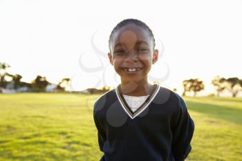 Portrait of African elementary school girl smiling in a park