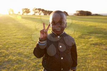 African elementary school boy making peace sign