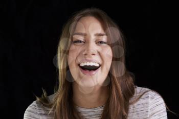 Head And Shoulders Studio Portrait Of Laughing Young Woman