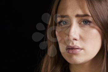 Close Up Head And Shoulders Studio Portrait Of Anxious Woman