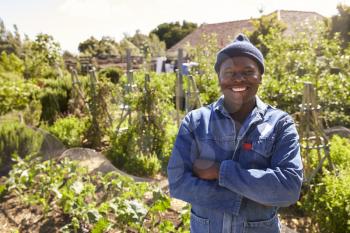 Portrait Of Gardener Standing In Community Allotment