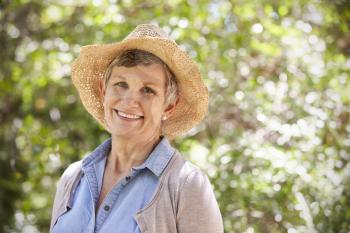 Outdoor Portrait Of Mature Woman Wearing Straw Hat