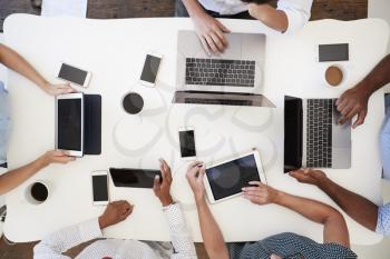 Group working at on computers with phones, overhead shot