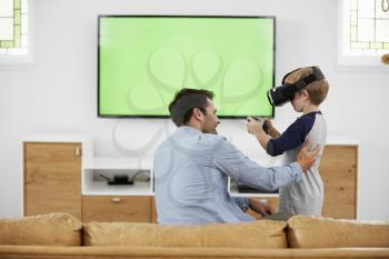 Father And Son Play Computer Game Using Virtual Reality Headset