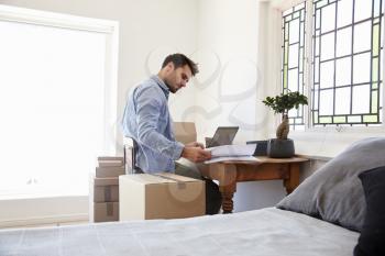 Man In Bedroom Running Business From Home Dispatching Goods