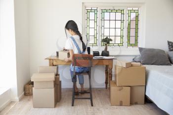 Woman In Bedroom Running Business From Home Dispatching Goods
