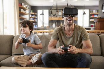 Father And Son Play Computer Game Using Virtual Reality Headset