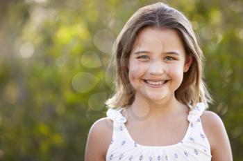 Portrait of smiling young girl looking to camera outdoors