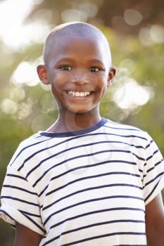 Smiling young black boy looking away from camera outdoors