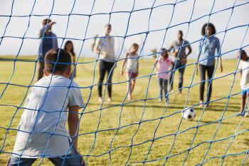Boy defending goal during a family football game