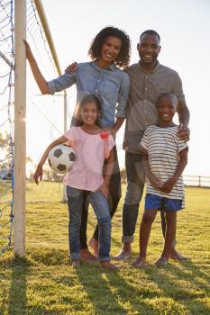 Portrait of a young black family next to a football goal