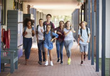 Teenager school kids running in high school hallway