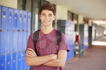 Happy teenage boy smiling in high school corridor
