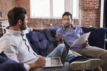 Businessmen Having Informal Meeting On Sofa In Modern Office