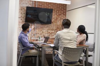 Businesspeople In Meeting Room Looking At Screen