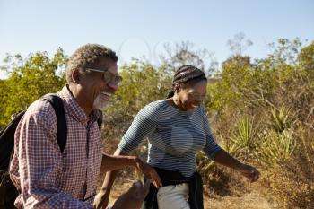 Mature Couple Hiking Outdoors In Countryside Together