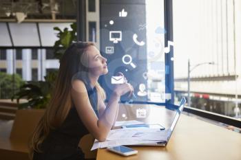 Businesswoman working in an office looking at app icons