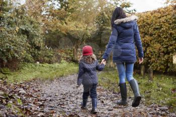 Mother And Daughter Holding Hands On Autumn Walk