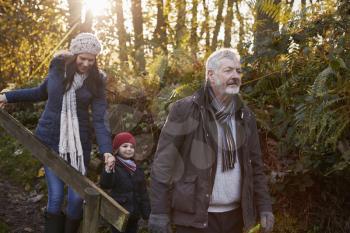 Multi Generation Family Enjoying Walk In Fall Landscape