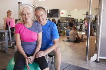 Portrait Of Active Senior Couple Exercising In Gym Together