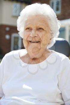 Portrait Of Senior Woman Sitting Outside Retirement Home