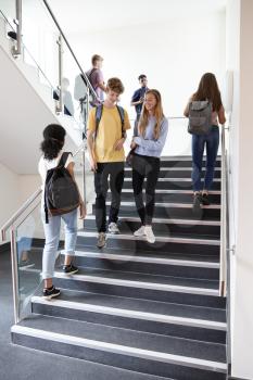 High School Students Walking On Stairs Between Lessons In Busy College Building