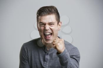 Portrait of a cheering young white man looking to camera