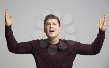 Portrait of a shocked young white man with arms in the air