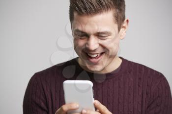 Close up portrait of a young white man using a smartphone