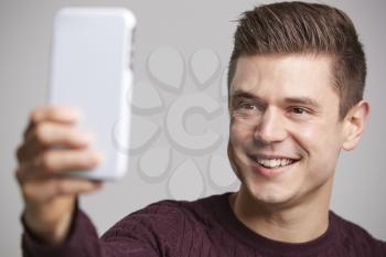 Close up of a young man taking a selfie with his smartphone