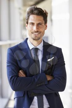 Portrait of young professional man in suit, arms crossed