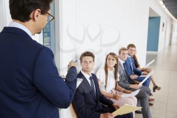 Recruiter addressing job candidates waiting for interviews