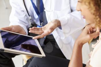 Two senior doctors using tablet computer, mid section