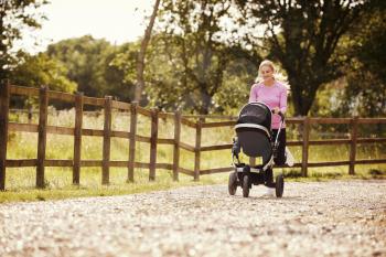 Mother Exercising By Running Whilst Pushing Baby Buggy