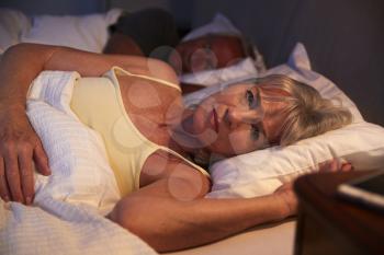 Worried Senior Woman In Bed At Night Suffering With Insomnia