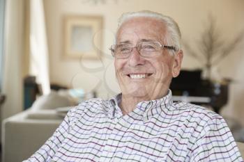 Happy senior man smiling to camera at home, close up