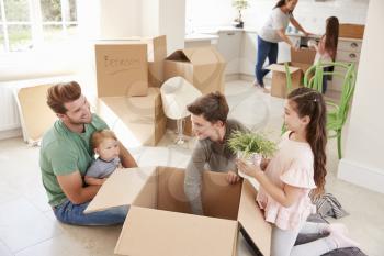 Children Helping Parents To Unpack On Moving In Day