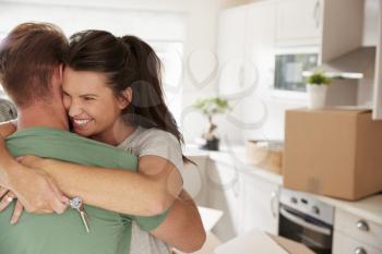 Hugging Couple Celebrating Moving Into New Home