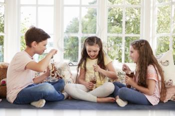 Children Sitting On Window Seat Eating Ice Cream Sundaes